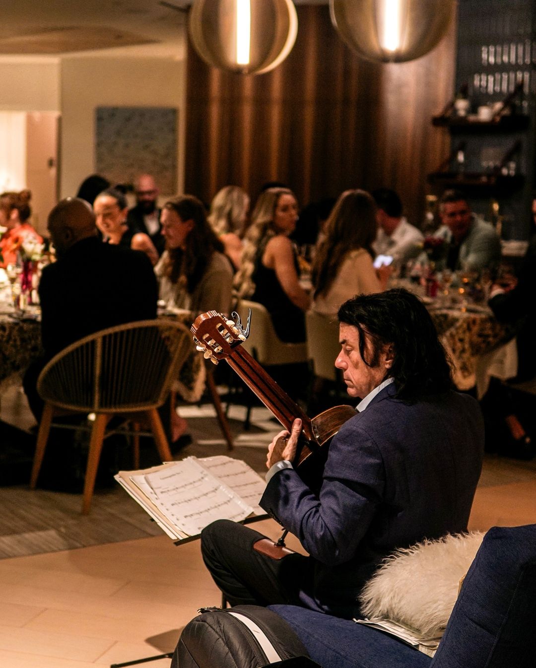Classical guitarist playing beside the dining room