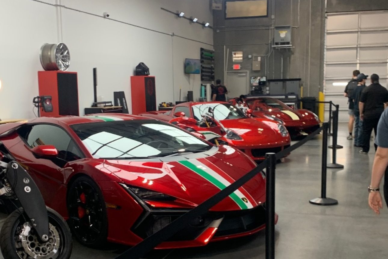 A row of red supercars inside Red Box Restoration